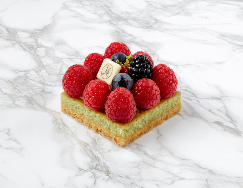 Un délice de fraises, framboises, mûres, myrtilles et groseilles posé sur un financier pistache.