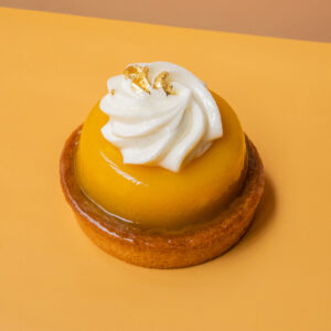 Une tarte individuelle fait de mangue (biscuit, de caramel et de fruit en gelée) et d'une ganache vanille