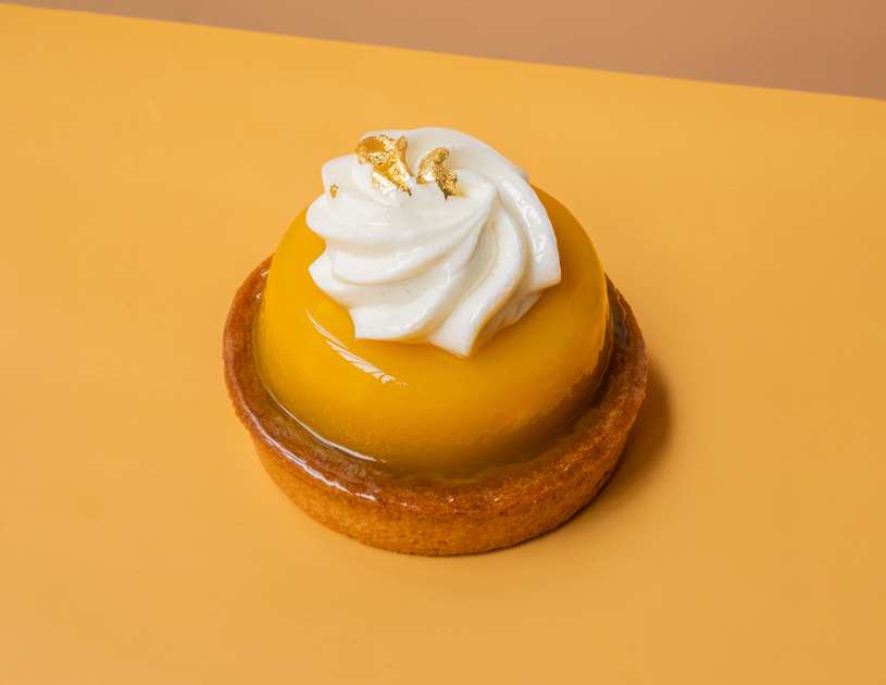 Une tarte individuelle fait de mangue (biscuit, de caramel et de fruit en gelée) et d'une ganache vanille