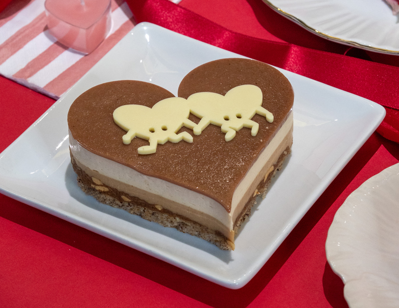 Pour les amoureux du chocolat, ce cœur est une véritable déclaration de gourmandise. Il associe praliné noisette‑amande, gianduja fondant, chocolats blanc et lait, et éclats de noisettes torréfiées pour une expérience riche et intense. Sa mousse onctueuse et son croustillant aux crêpes dentelles offrent un jeu de textures irrésistible. Chaleureux, réconfortant et terriblement addictif, c’est le dessert parfait pour fondre de plaisir. Disponible en solo ou en duo.